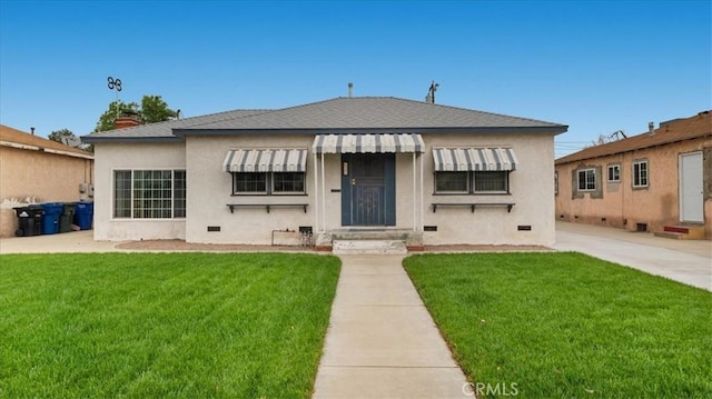 bungalow-style home featuring a front yard and stucco siding