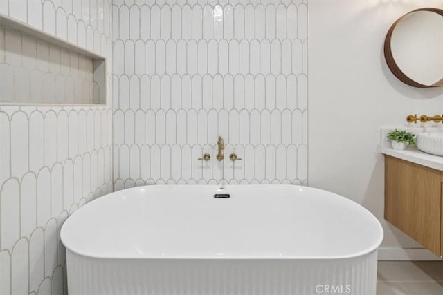 full bathroom with vanity, a soaking tub, and tile patterned flooring