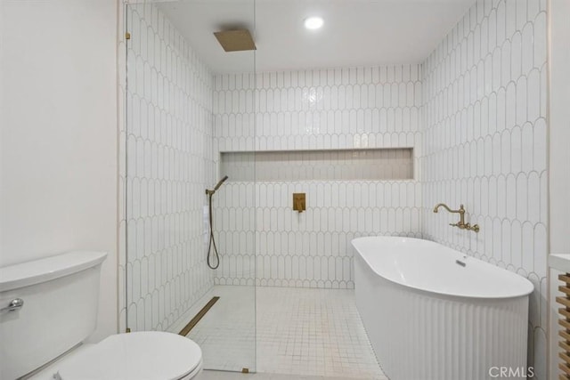 full bath with tile patterned flooring, a soaking tub, toilet, and a walk in shower