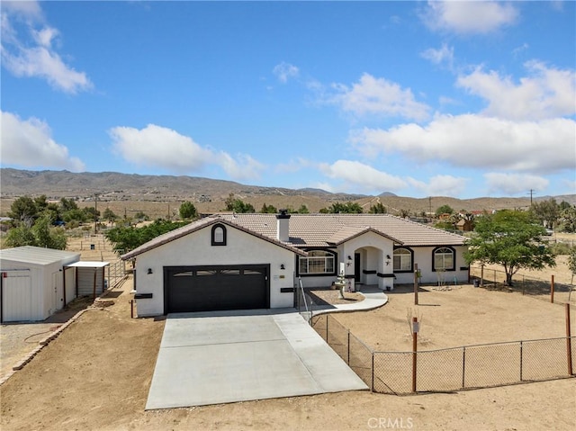 single story home featuring a tile roof, stucco siding, fence, a mountain view, and driveway