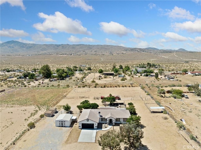 drone / aerial view featuring a mountain view, a desert view, and a rural view