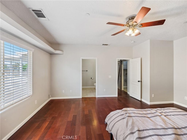 bedroom featuring baseboards, visible vents, and wood finished floors