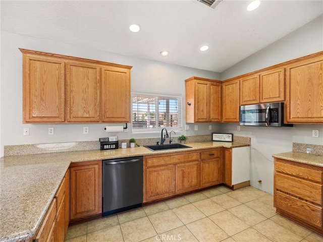 kitchen featuring brown cabinets, vaulted ceiling, stainless steel appliances, a sink, and recessed lighting