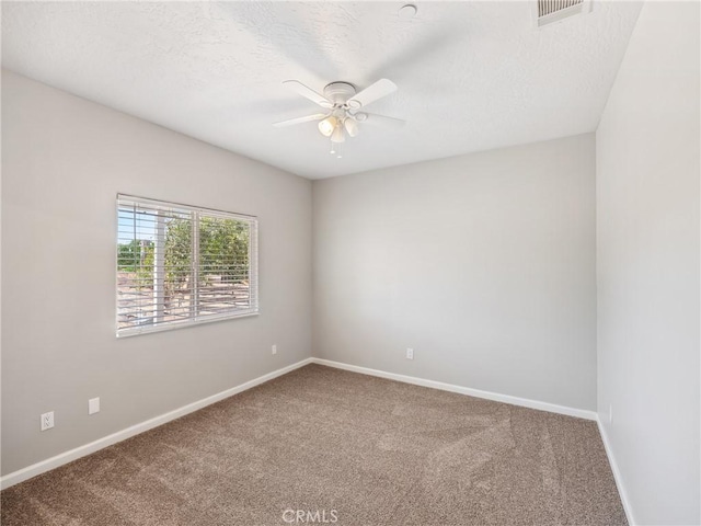 empty room featuring baseboards, visible vents, ceiling fan, and carpet flooring