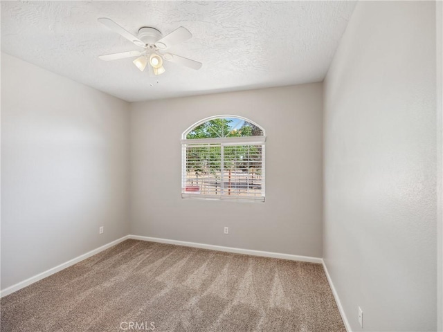 spare room featuring carpet, baseboards, ceiling fan, and a textured ceiling