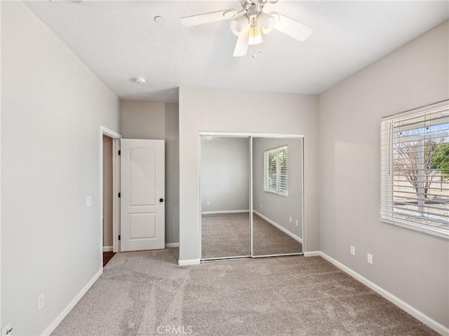 unfurnished bedroom with a ceiling fan, carpet, baseboards, and a closet