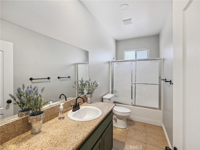 full bathroom with visible vents, toilet, combined bath / shower with glass door, vanity, and tile patterned flooring