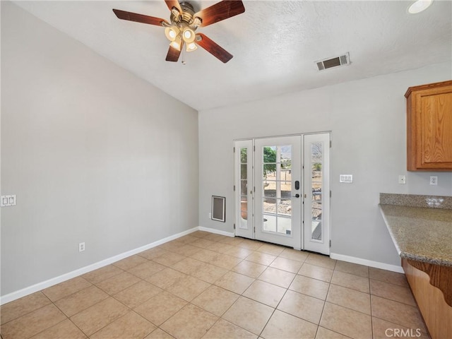 interior space with light tile patterned floors, visible vents, baseboards, ceiling fan, and a textured ceiling