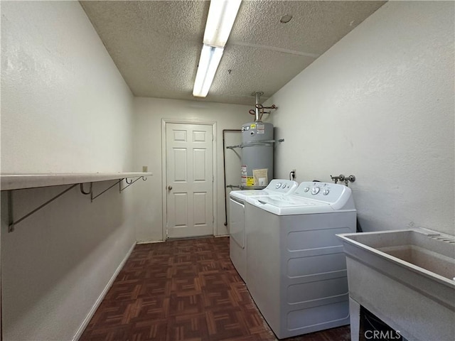 washroom with a textured ceiling, laundry area, a sink, secured water heater, and washer and clothes dryer