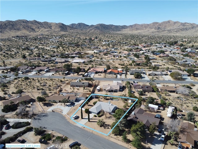 drone / aerial view featuring a desert view and a mountain view