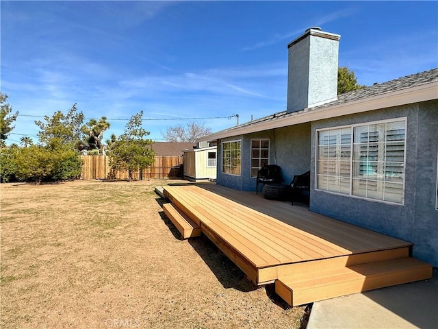 wooden terrace featuring fence and a lawn