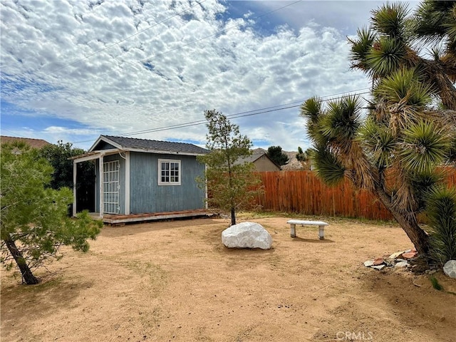 view of yard with fence and an outbuilding