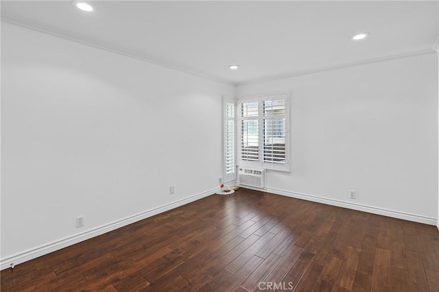 spare room with recessed lighting, an AC wall unit, baseboards, and wood finished floors