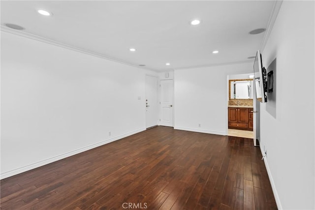 spare room with dark wood-style floors, baseboards, crown molding, and recessed lighting