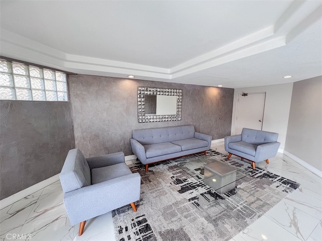 living room featuring marble finish floor, recessed lighting, a raised ceiling, and baseboards