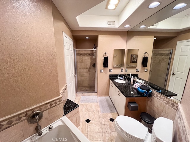 full bath with tile walls, a raised ceiling, a shower stall, and toilet