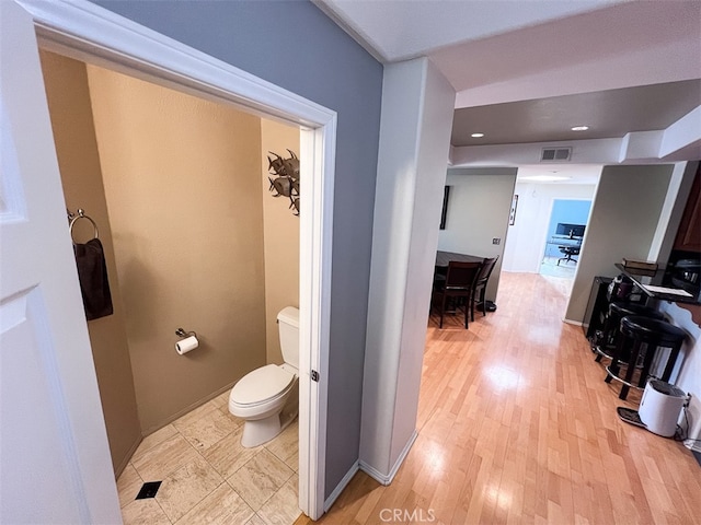 corridor featuring baseboards, recessed lighting, visible vents, and light wood-style floors