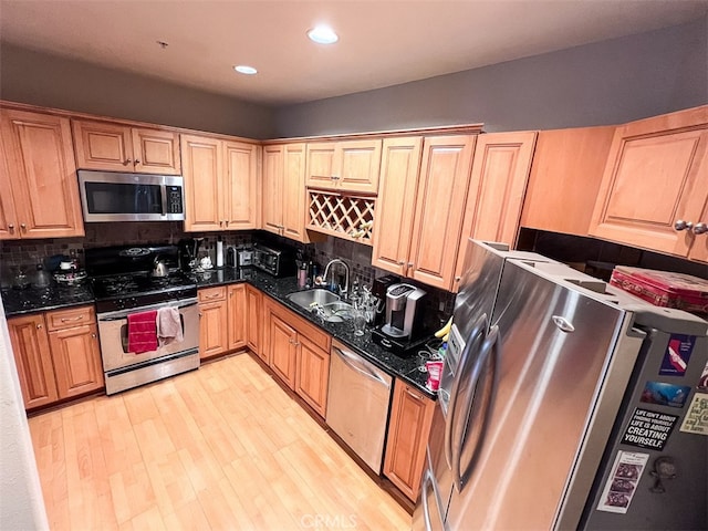 kitchen with decorative backsplash, light wood-style flooring, stainless steel appliances, a sink, and recessed lighting