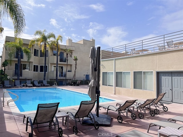 community pool featuring a patio and fence