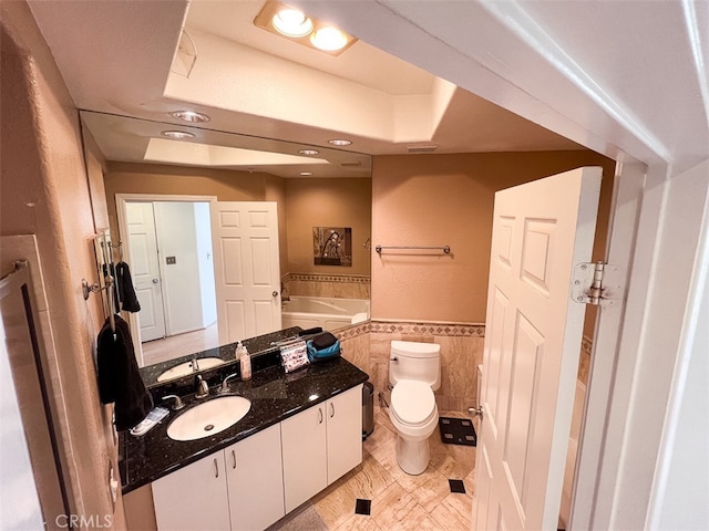 bathroom featuring tile walls, visible vents, toilet, wainscoting, and vanity