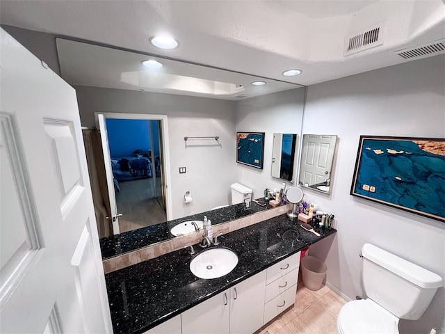 bathroom featuring toilet, vanity, visible vents, and recessed lighting