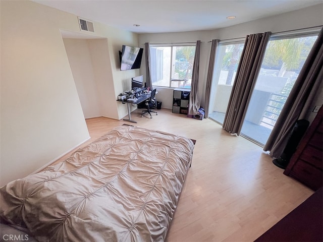 bedroom with access to outside, visible vents, and wood finished floors