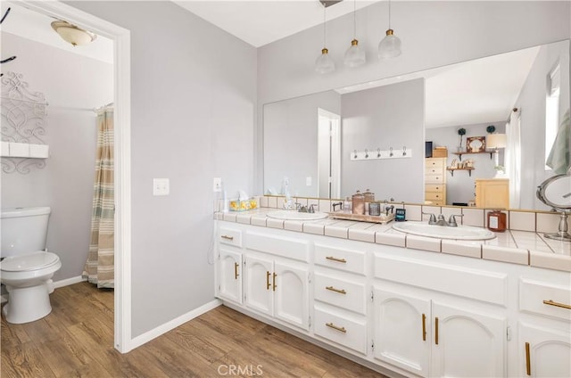 bathroom featuring a sink, toilet, and wood finished floors