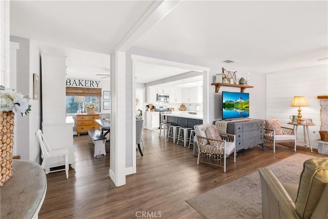 living room featuring visible vents, ceiling fan, and wood finished floors