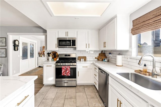 kitchen featuring white cabinetry, stainless steel appliances, and a sink