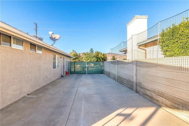 view of patio featuring fence and a gate