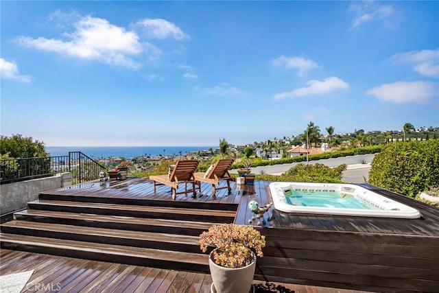 exterior space with a deck with water view and hot tub deck surround