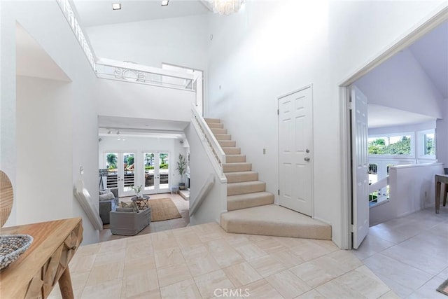 stairs with french doors and a high ceiling