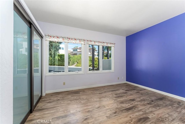 unfurnished room featuring baseboards and wood finished floors