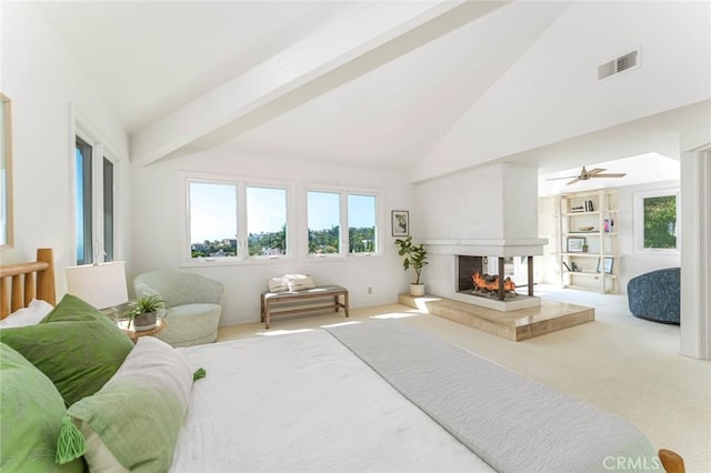 bedroom with carpet floors, multiple windows, a multi sided fireplace, and beamed ceiling