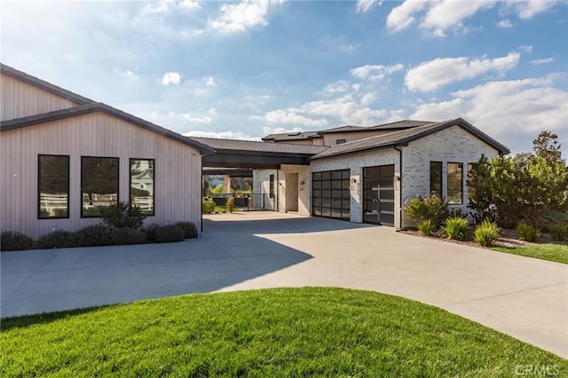 view of front of house featuring concrete driveway, brick siding, a front lawn, and an attached garage