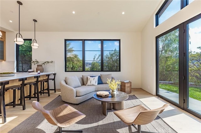 living area featuring lofted ceiling, light wood finished floors, and recessed lighting