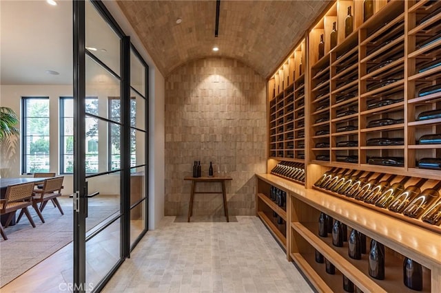 wine area with brick ceiling, french doors, vaulted ceiling, and recessed lighting