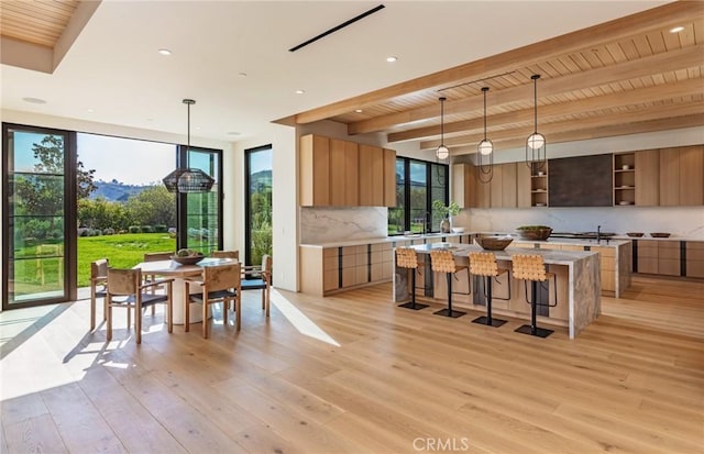 kitchen featuring a center island, light wood finished floors, open shelves, light countertops, and modern cabinets