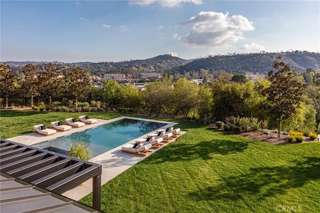 outdoor pool featuring a patio area, a yard, and a mountain view