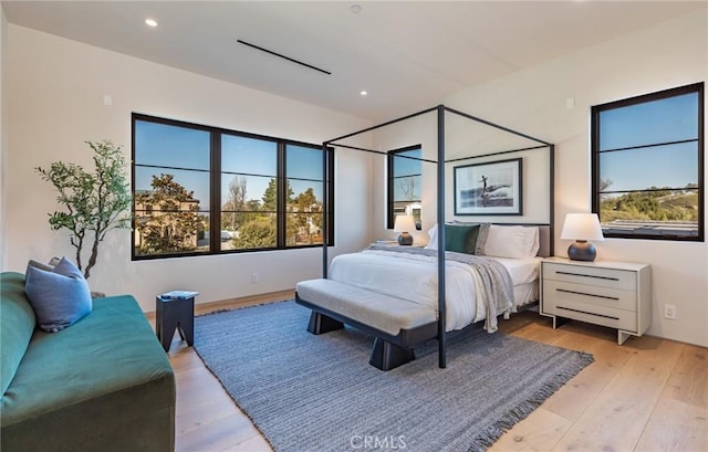 bedroom with light wood finished floors, multiple windows, and recessed lighting