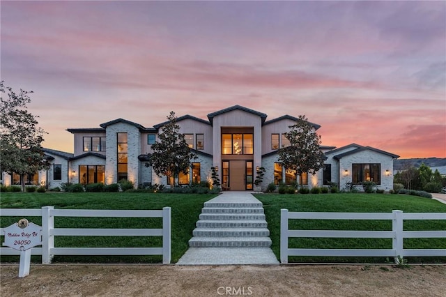 contemporary home featuring a lawn and a fenced front yard