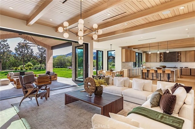 living room with a chandelier, recessed lighting, wood ceiling, beam ceiling, and light wood finished floors