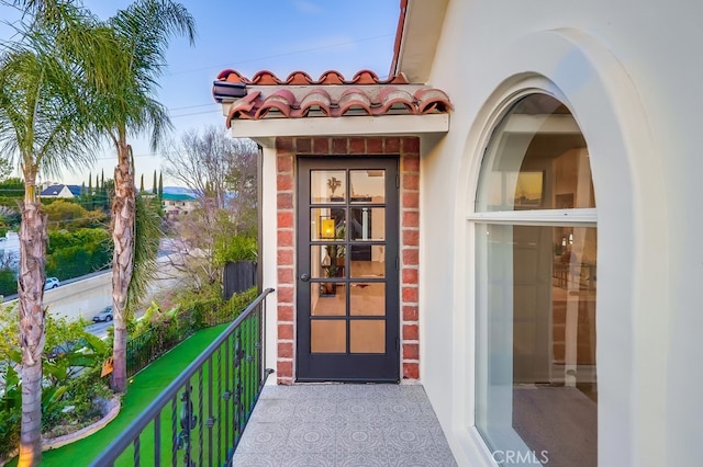 view of exterior entry featuring a balcony