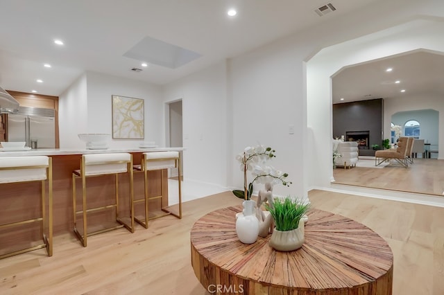 interior space featuring light wood-type flooring, a large fireplace, visible vents, and recessed lighting