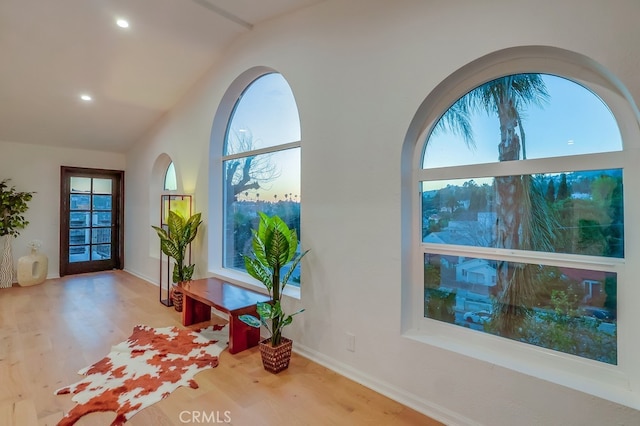 entryway featuring recessed lighting, a healthy amount of sunlight, vaulted ceiling, and wood finished floors