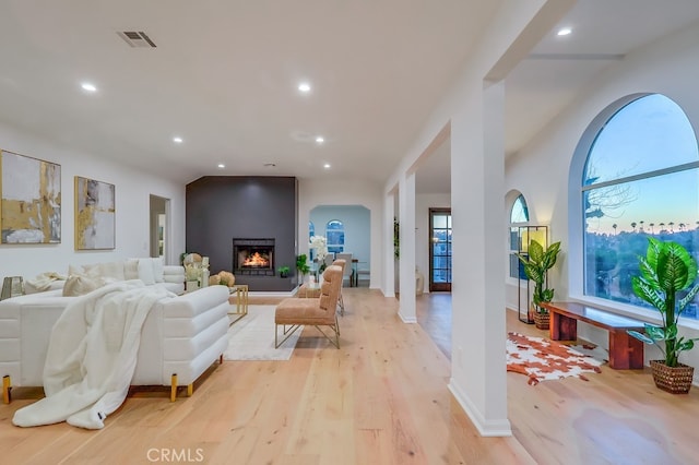 living room featuring light wood-type flooring, visible vents, and recessed lighting