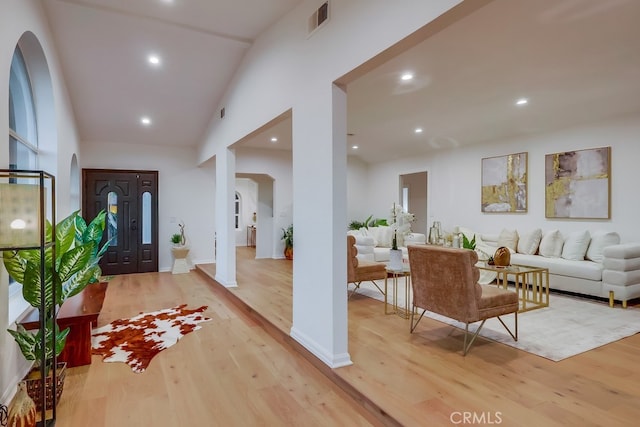 foyer entrance with visible vents, arched walkways, wood finished floors, and recessed lighting