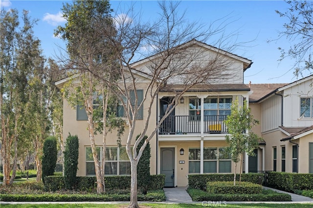 townhome / multi-family property with a balcony and stucco siding