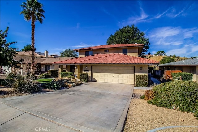 mediterranean / spanish-style house featuring a garage, concrete driveway, a tiled roof, and stucco siding