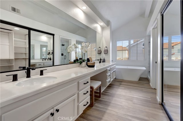 full bathroom with visible vents, lofted ceiling, a soaking tub, a sink, and a shower stall